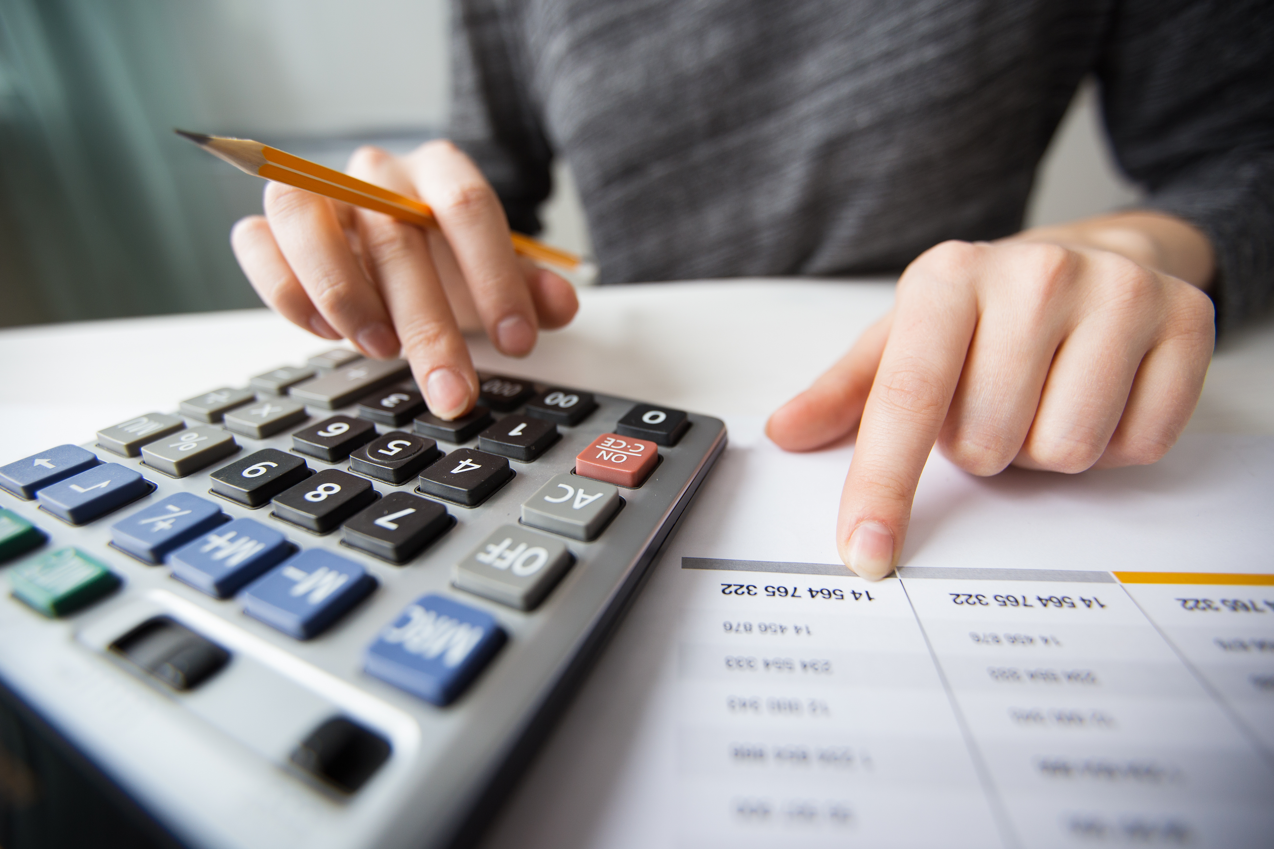 Person planning finances with calculator and documents